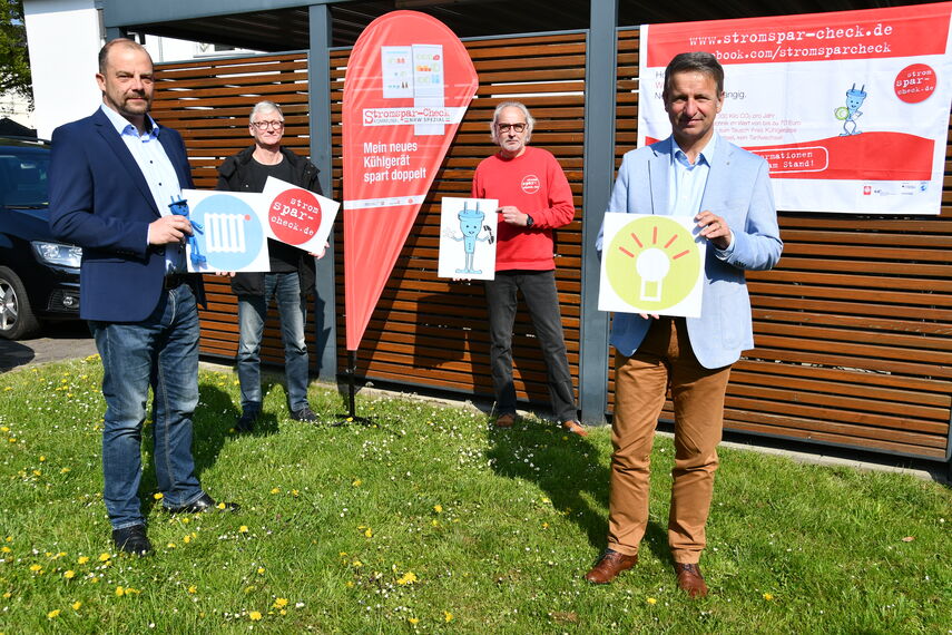 4 Personen halten Informationen zum Strompsarcheck in den Händen.