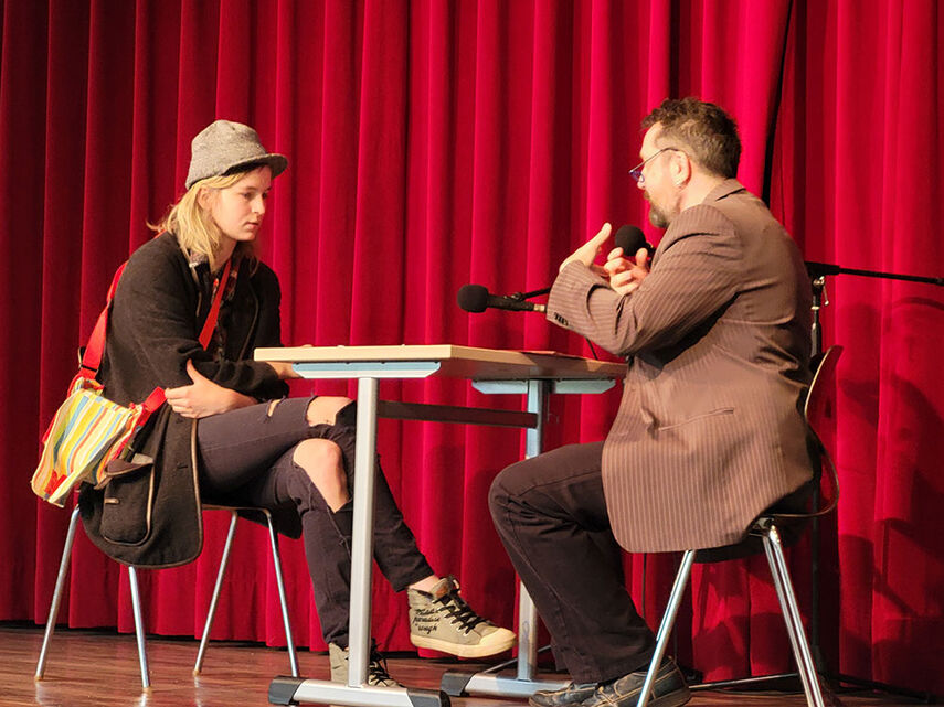 2 Personen sitzen am Tisch und proben ein Vorstellungsgespräch